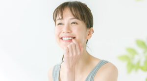 口元を指差す、笑顔の女性